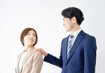 白バックでビジネスウーマンの肩を掴むビジネスマン