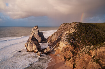 Portugal Ursa Beach at сoast of Atlantic Ocean. Rocks and waves at sand of coastline picturesque landscape.