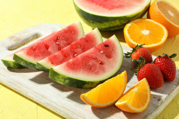 Tasty fresh fruits on yellow textured table