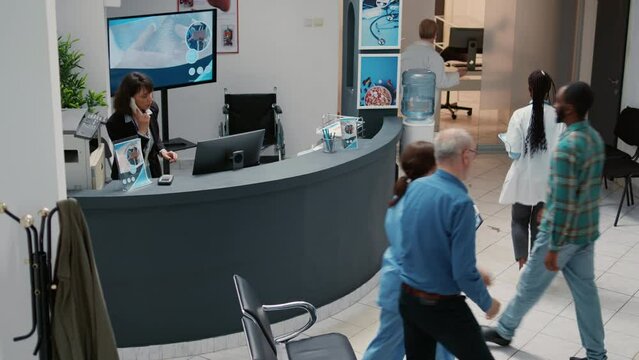 Diverse people and mother with child waiting in hospital reception lobby to do checkup consultation at medical facility. Group of patients having examination appointment with medic.