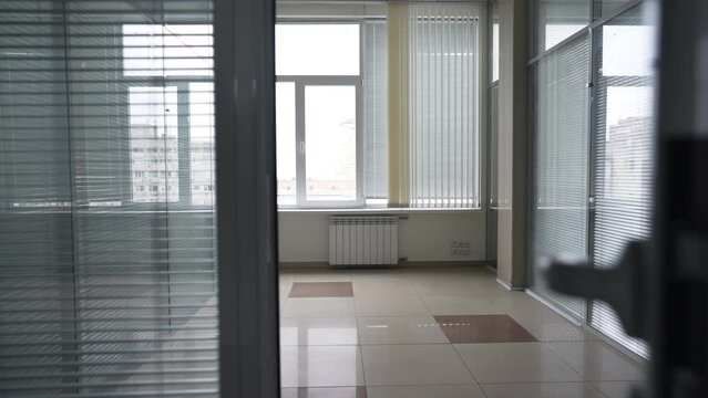 Live camera entering empty office with no furniture for rent. Personal POV of modern corporate real estate for sale indoors in city downtown