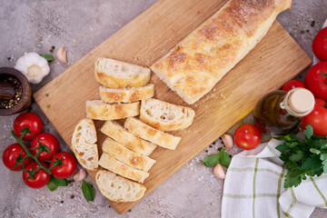 Sliced French bread baguette on wooden bread board