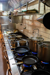 gas stove in the kitchen full of pots and pans