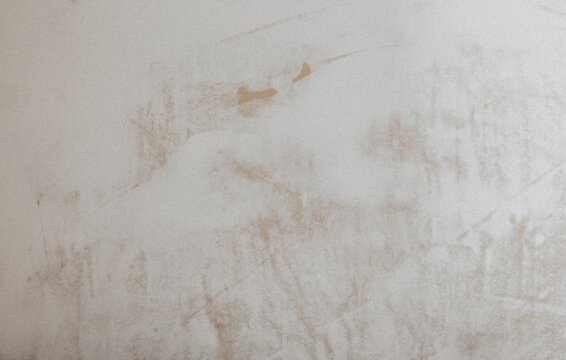 A drywall plastered surface with rough brush strokes texture. Paint brushed old white wall background.