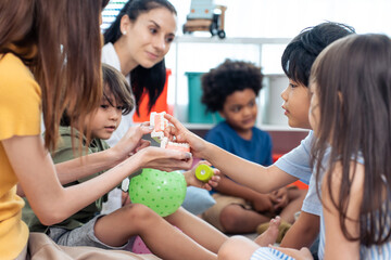 Caucasian beautiful woman teacher teach fun activity to kids at school	