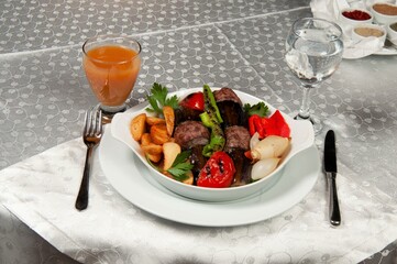 Eggplant kebab on a porcelain plate. Eggplant kebab is made from meat, eggplant, onions, tomatoes, parsley, potatoes and peppers.