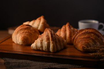 Tasty buttery croissants on black wooden table. Levitation, bread bakery products cafe concept