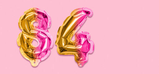 Rainbow foil balloon number, digit eighty four on a pink background. Birthday greeting card with inscription 84. Top view. Numerical digit. Celebration event, template. Banner