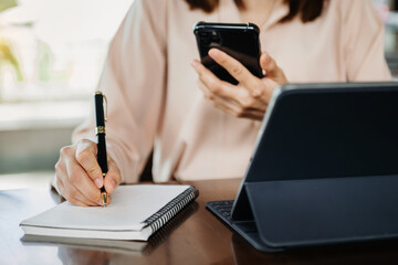 businesswoman hand working with new modern computer and writing on the notepad strategy diagram