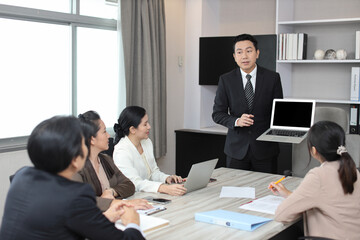 Collaborative process of professional businesspeople going over on new project together, using computer presentation and brainstorming ideas, coworker and working together at office meeting concept