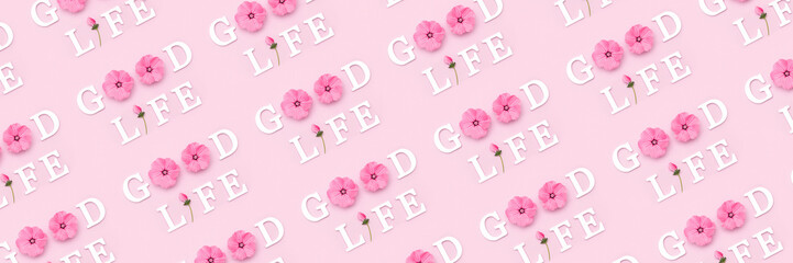 Good life. Creative banner made with motivational quotes from white letters and beauty natural flowers on pink background