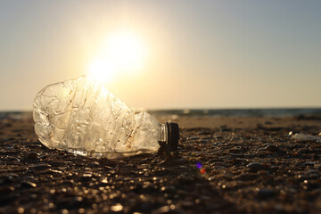 Plastic bottle thrown on the beach . Concept of environmental pollution and damage to nature and animals