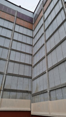 Typical panel house. Old urban residential house in Europe. Ordinary soviet building. Facade of a multi-storey house. Industrial background. Two residential buildings make a corner.