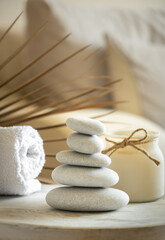 Sea stones balance on wooden table, candle and towel, spa and relax concept, free space for text, selective focus banner