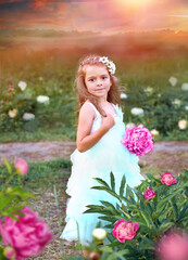 Cute girl in an airy mint color dress with a large pink peony in the garden. Summer. Background - sunset, rays, bokeh effect. Summer concept