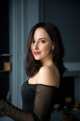 portrait of a young beautiful smiling brunette woman in dark room
