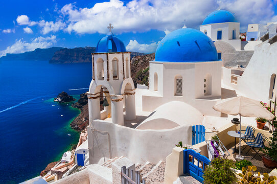 Iconic view with blue domes churches  and caldera of most beautiful island  - Santorini,  Oia village, Cyclades . Greece