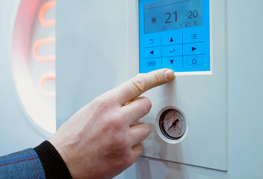 Man hand touching control panel sensor of a heat pump comfort system