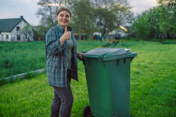 Plastic pollution problem. European 20s girl take out the trash can sorting garbage near a home. Put trash in garbage containers. Volunteers and responsible society.