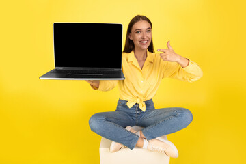 Happy Woman Showing Laptop Computer With Empty Screen, Yellow Background - obrazy, fototapety, plakaty