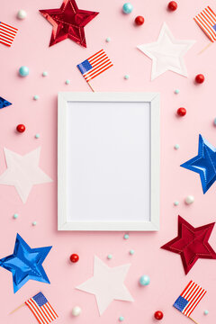 Fourth of July concept. Top view vertical photo of photo frame US national flags stars and scattered candies on isolated pastel pink background with empty space