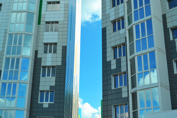 Blue sky between new glass windows of houses