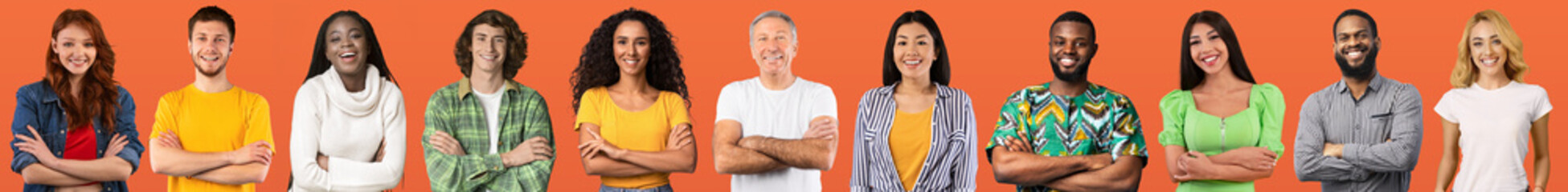 Beautiful international team posing on orange studio background