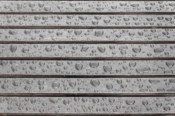 Wooden planks covered by water drops, background for rainy weather. Wet brown boards close up....