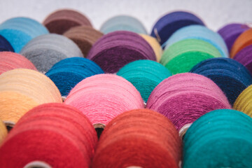 Colourful threads from clothing factory. Different colours of bright threads used in apparel...