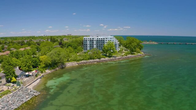 4K Aerial view of a condo on the waterfront. Beautiful summer day, Burlington Ontario. Toronto visible way off in the distance.