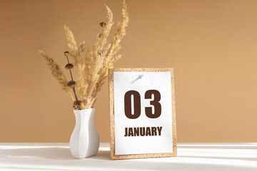 january 3. 3th day of month, calendar date.White vase with dried flowers on desktop in rays of sunlight on white-beige background. Concept of day of year, time planner, winter month