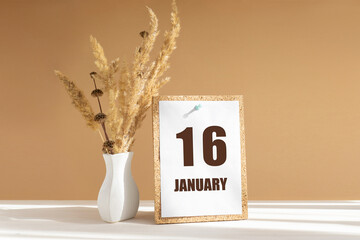 january 16. 16th day of month, calendar date.White vase with dried flowers on desktop in rays of sunlight on white-beige background. Concept of day of year, time planner, winter month