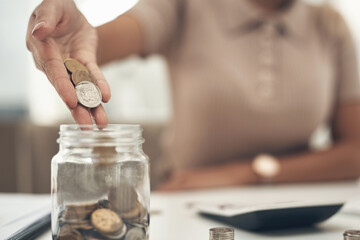 Obraz na płótnie Canvas Storing a few extra pennies into the money jar