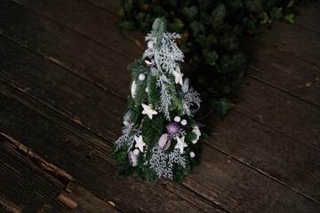 Christmas tree handmade. Floral Christmas tree. A gift version of the Christmas tree. Natural nobilis. White and lilac toys on the branches of a decorative Christmas tree made of natural needles.