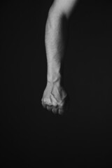 Brutal mans hand with protruding veins, black background.Black and white photo.