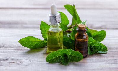 Peppermint essential oil in a small bottle. Selective focus.