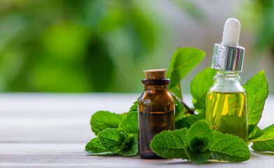 Peppermint essential oil in a small bottle. Selective focus.