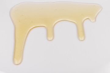 Honey flows. Drops of yellow syrup flow. Natural product and sweet drink. Isolated on white background.