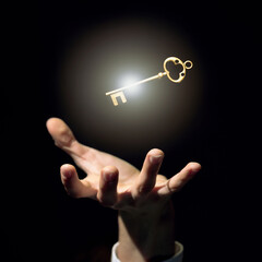 a businessman's hand is trying to grab a golden key a symbol of good luck and wealth