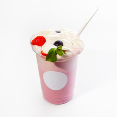 Cool delicious berry-flavored milkshake with whipped cream decorated with wild berries. Close-up, on a white background. Mock up