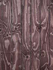 Vertikal ausgerichtete braune Holzbretter mit intensiver Maserung als Hintergrund