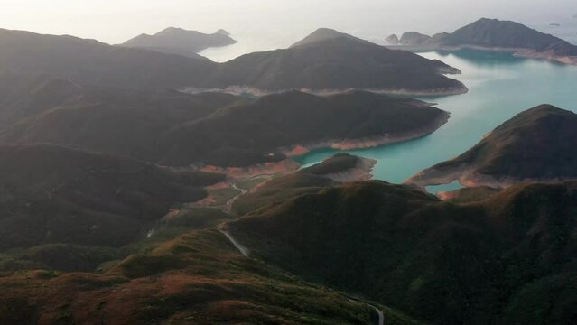 Aerial cinematic shot of High Island Reservoir East Dam in Sai Kung Hong Kong.  It is a rare volcanic hexagonal rock columns, beaches and islands, geological formations, sea bay.