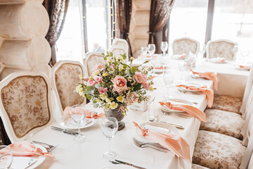 Luxury table setting for dining in a restaurant in pastel colors close up. Wedding party table set for banquet