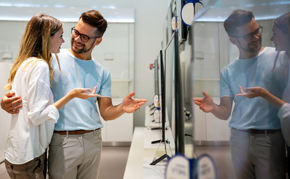 Portrait of happy couple shopping in a tech store. Technology people smart device concept