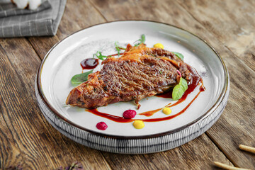 Portion of gourmet grilled beef steak on wooden background