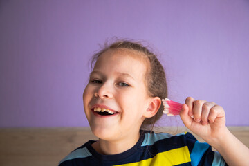 a child girl in a striped turtleneck puts a lot of cotton sticks in her ear, not much dirt will fit