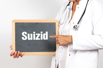 Eine Ärztin zeigt auf eine Tafel auf der SUIZID steht