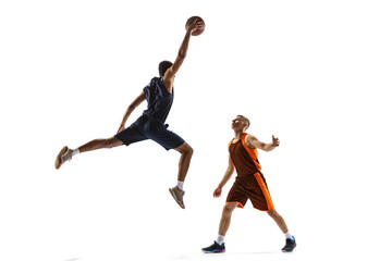 Dynamic portrait of two young men, professional basketball players in motion, training isolated...