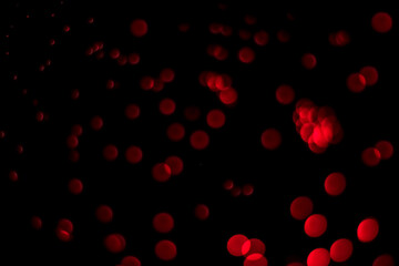 Blurred glitter background with round red bokeh