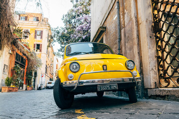 Fototapeta premium rome, italy. 17th april, 2022: a classic fiat 500 vehicle is parked in roman street